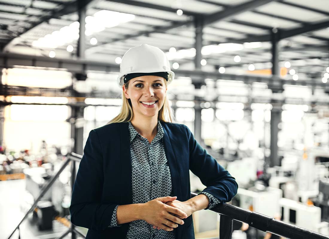 Engineer Insurance - A Portrait of an Industrial Woman Engineer Standing in a Large Factory