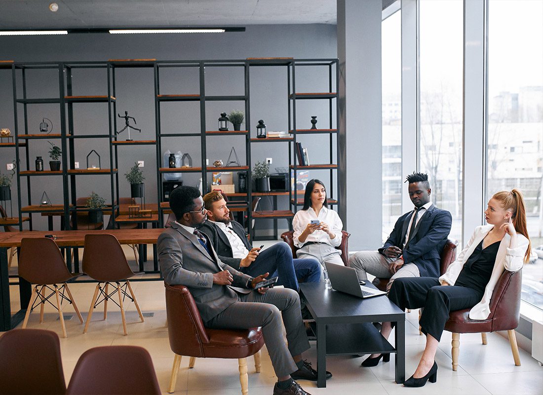 About Our Agency - A Group of Business Partners Discussing A Future Successful Deal in a Modern Office While Wearing Formal Wear