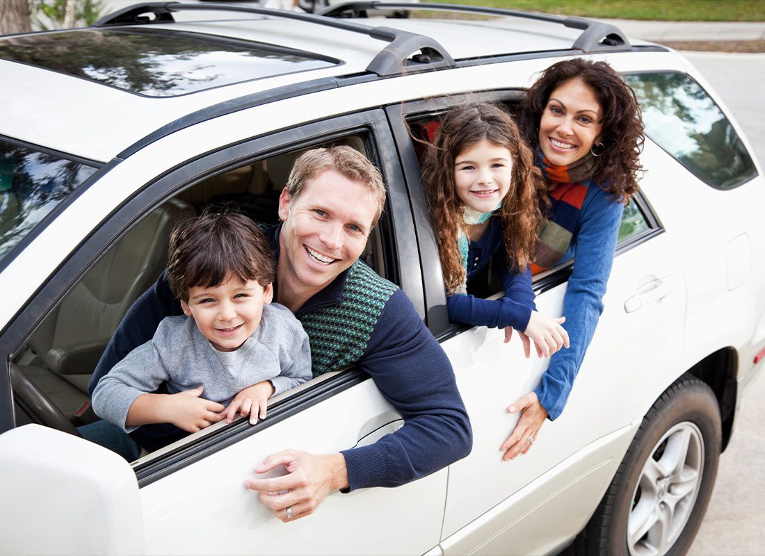 Personal Insurance - A Family Riding Together in A Car While Sticking Their Heads Out the Car Window